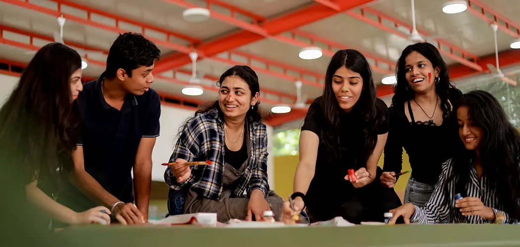 SDI students painting together at a long studio table